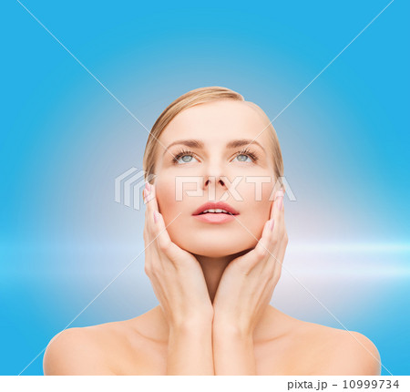 beautiful woman touching her face and looking up beautiful woman touching her face and looking up 10999734