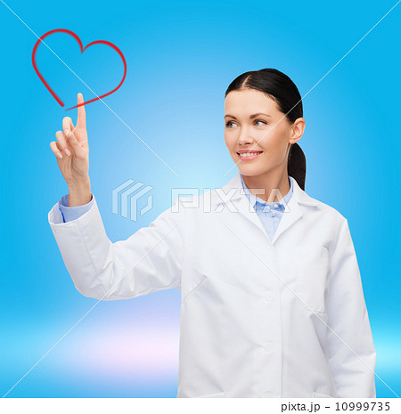 smiling female doctor pointing to heart 10999735