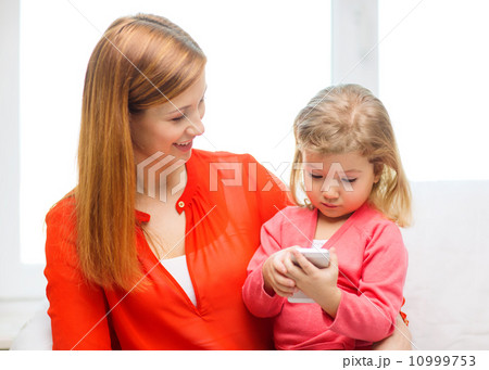 happy mother and daughter with smartphone at home 10999753