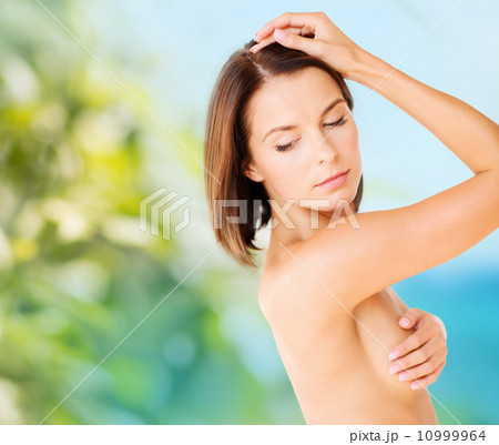 woman checking breast for signs of cancer woman checking breast for signs of cancer 10999964
