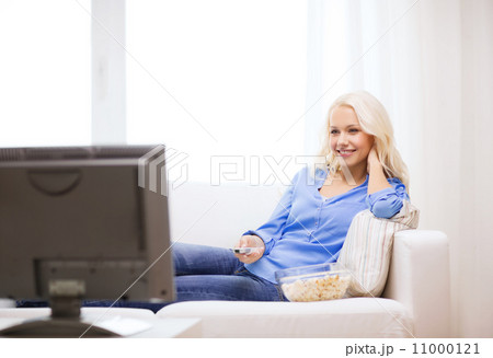 young girl with popcorn watching movie at home 11000121