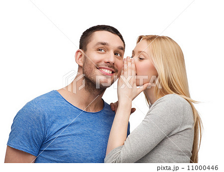 smiling girlfriend telling boyfriend secret 11000446