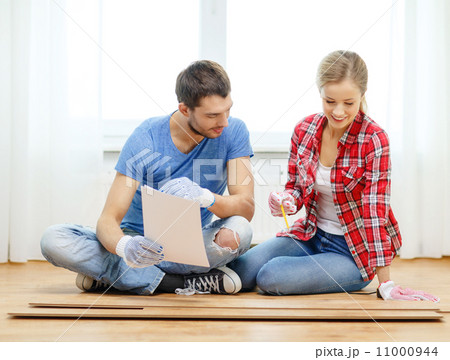 smiling couple measuring wood flooring smiling couple measuring wood flooring 11000944