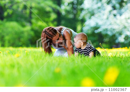 Mother and daughter on the green grass 11002367