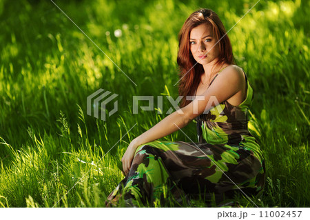 brunette sitting on green grass brunette sitting on green grass 11002457