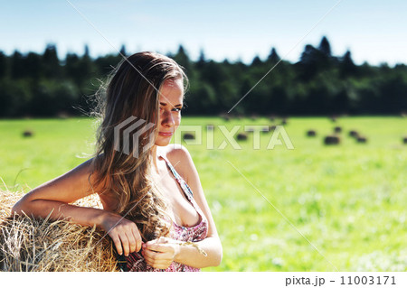 girl next to a stack of hay girl next to a stack of hay 11003171
