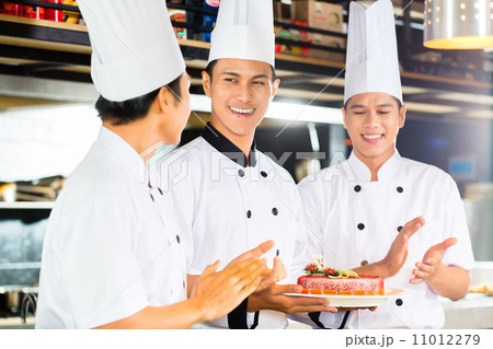 Asian chefs cooking in Restaurant 11012279