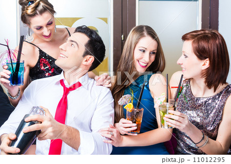Friends celebrating with barkeeper in cocktail bar 11012295