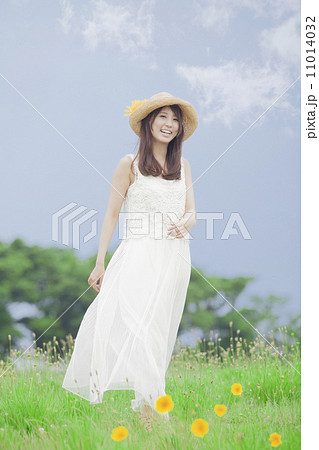 麦わら帽子と白いワンピースの女性の写真素材