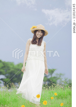 麦わら帽子と白いワンピースの女性の写真素材