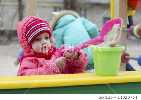 little girl pours sand bucket in sandbox little girl pours sand bucket in sandbox 11020751