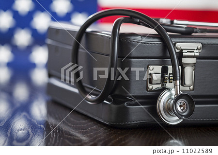Briefcase and Stethoscope Resting on Table with American Flag Be 11022589