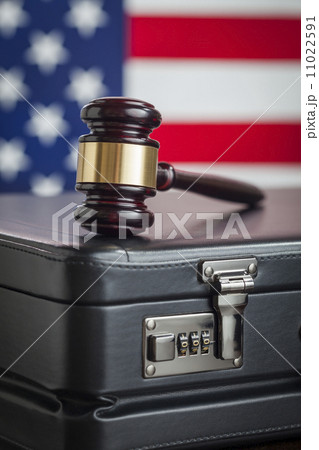 Briefcase and Gavel Resting on Table with American Flag Behind Briefcase and Gavel Resting on Table with American Flag Behind 11022591