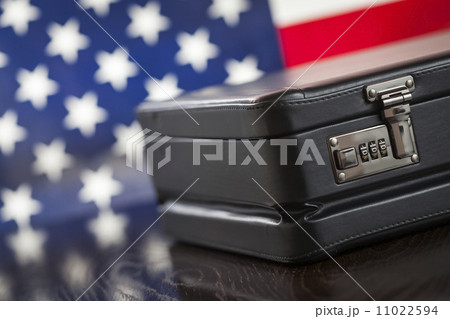 Leather Briefcase Resting on Table with American Flag Behind 11022594