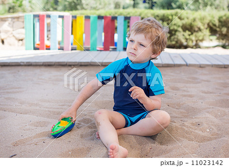 Little toddler boy playing with sand and toy Little toddler boy playing with sand and toy 11023142