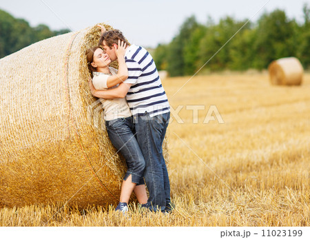 Young couple in love on yellow hay field on summer evening. Young couple in love on yellow hay field on summer evening. 11023199