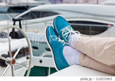 Legs in pants and bright blue topsiders on yacht 11025963