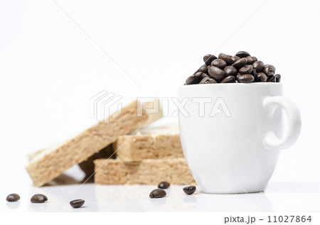 A close up shot of coffee beans in coffee cup and bread A close up shot of coffee beans in coffee cup and bread 11027864