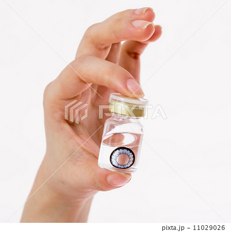 cosmetic contact lenses in bottle with  hand 11029026