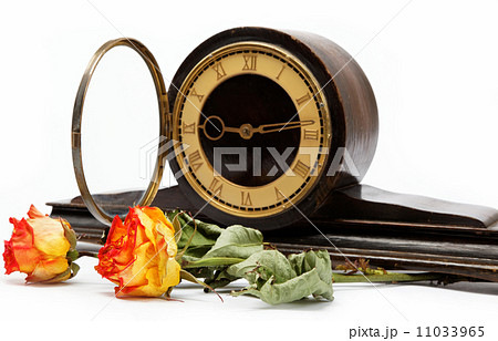 Antique wooden table clock  and flouvers on a white background. 11033965