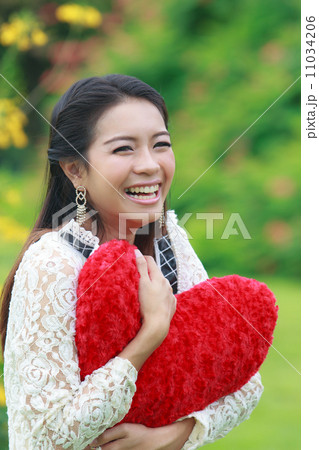 Asian woman holding a red heart 11034206