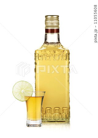 Bottle of gold tequila and shot with lime slice Bottle of gold tequila and shot with lime slice 11055608