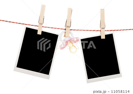 Instant photo frames and pacifier hanging on the clothesline 11058114