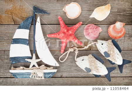Toy sailboat and fish with seashells and starfish 11058464