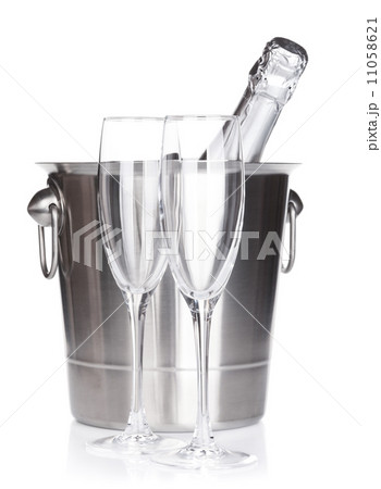 Champagne bottle in bucket and empty glasses 11058621