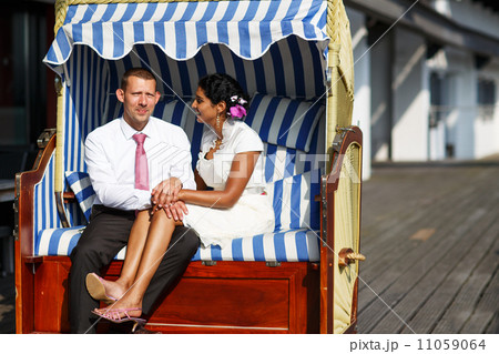 Beautiful indian bride and caucasian groom, in beach chair. Beautiful indian bride and caucasian groom, in beach chair. 11059064