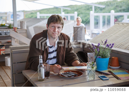 Young beautiful man in summer outdoor restaurant 11059088