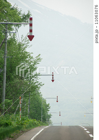 北海道の道路沿いにある赤と白の矢印標識の写真素材