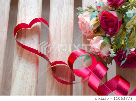 Red satin ribbon heart with artificial rose flowers 11063778