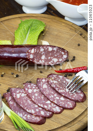 sausages on a wooden plate with vegetables in a restaurant sausages on a wooden plate with vegetables in a restaurant 11065023