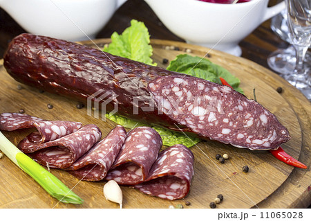sausages on a wooden plate with vegetables in a restaurant sausages on a wooden plate with vegetables in a restaurant 11065028