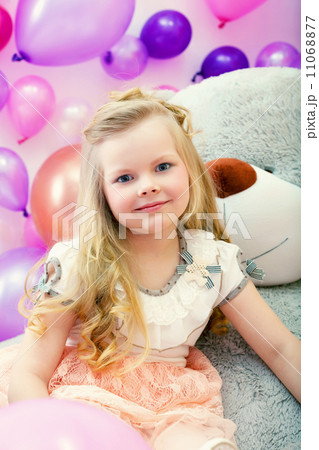 Smiling little blonde posing with big toy Smiling little blonde posing with big toy 11068877