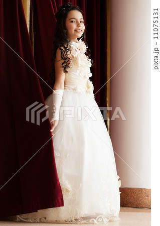 Smiling girl in elegant dress coming out of scenes 11075131
