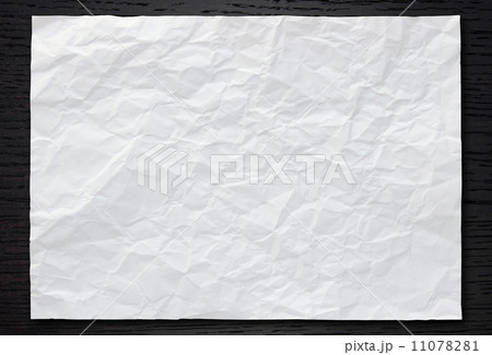 White crumpled paper on dark wood background 11078281