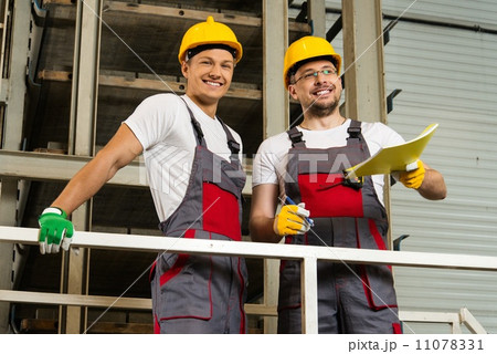 Two positive workers  in safety hats on a factory 11078331