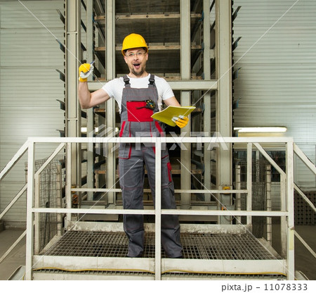 Funny worker in safety hat on a factory 11078333