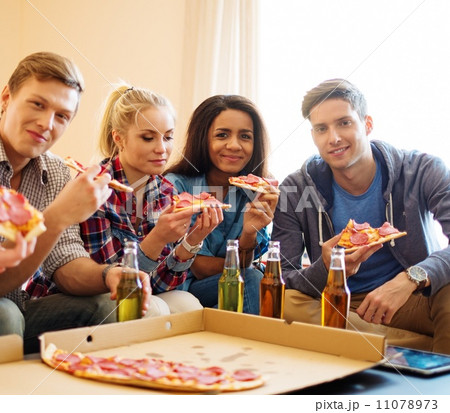 Group of young multi ethnic friends with pizza and bottles of drink celebrating in home interior Group of young multi ethnic friends with pizza and bottles of drink celebrating in home interior 11078973