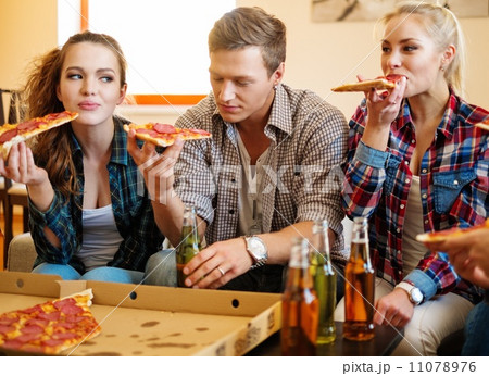Group of friends eating pizza in home interior Group of friends eating pizza in home interior 11078976