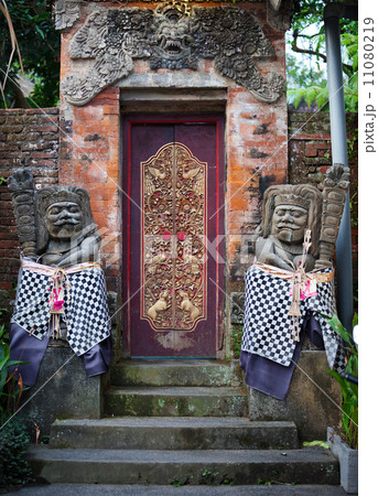 Gates of the old temple with stone guards. Indonesia, Bali. 11080219
