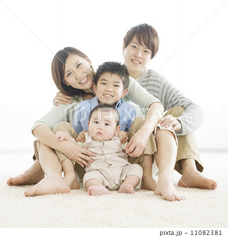 床に座り微笑む家族 11082381