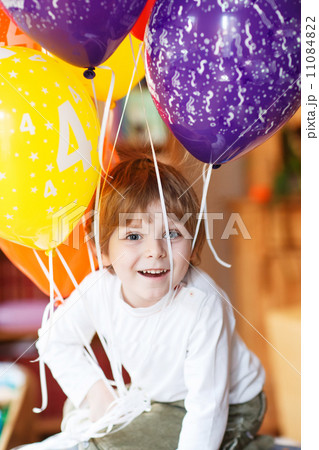 Happy little boy celebrating his 4 birthday with colorful balloo 11084822