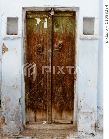 Rotten wooden door of an old house. India, Udaipur 11088234