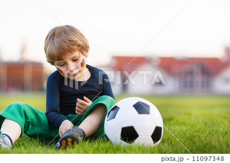 Blond boy of 4 playing soccer with football on football field Blond boy of 4 playing soccer with football on football field 11097348