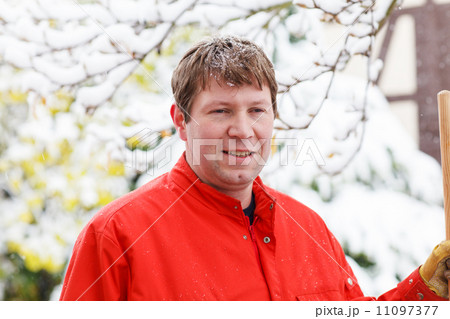Portrait of young man in working clothes cleaning snow outdoors. Portrait of young man in working clothes cleaning snow outdoors. 11097377