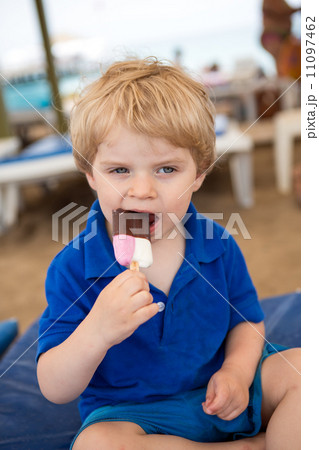 Little blond toddler eating chocolate ice cream Little blond toddler eating chocolate ice cream 11097462