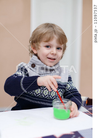 Cute toddler boy having fun indoor, painting with different pain 11097537